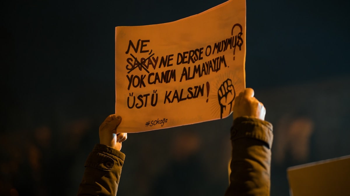Protester holds sign with turkish text.